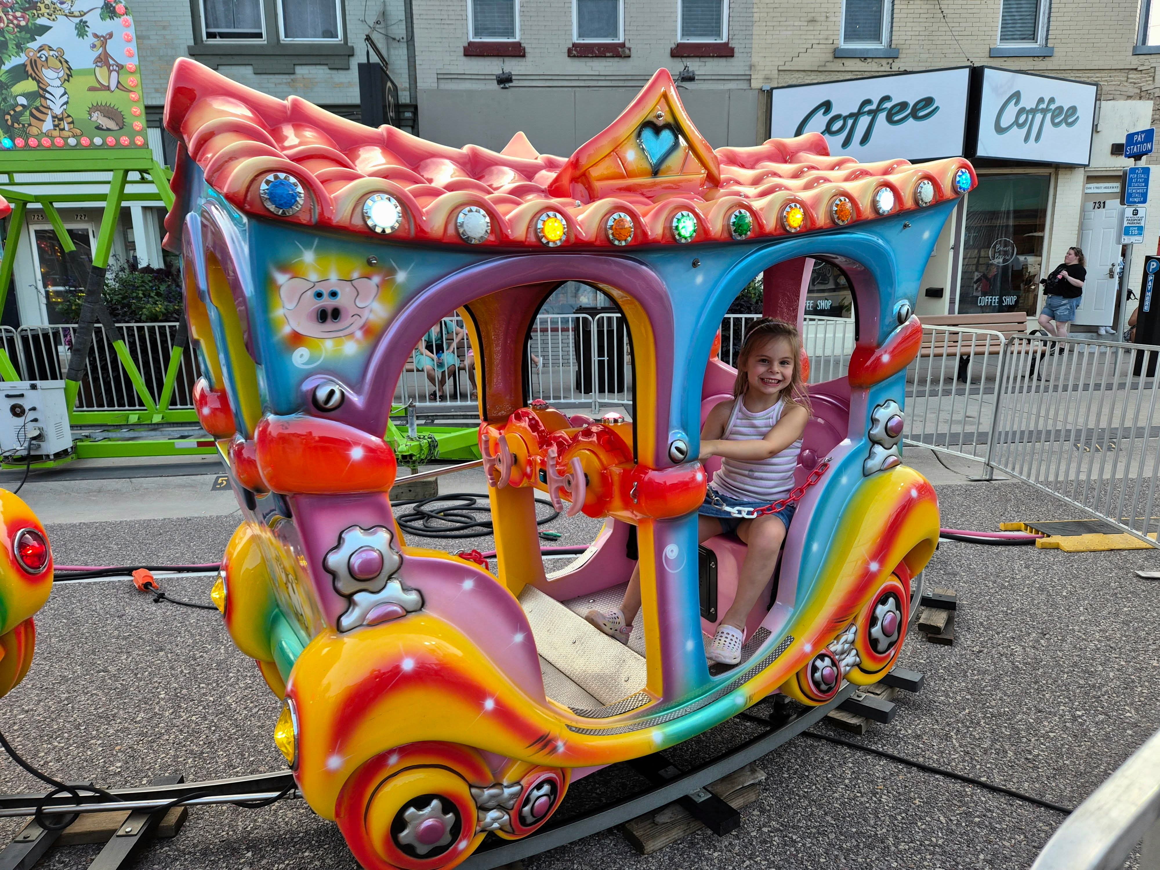 A child riding a colorful carnival ride in downtown Wisconsin Dells