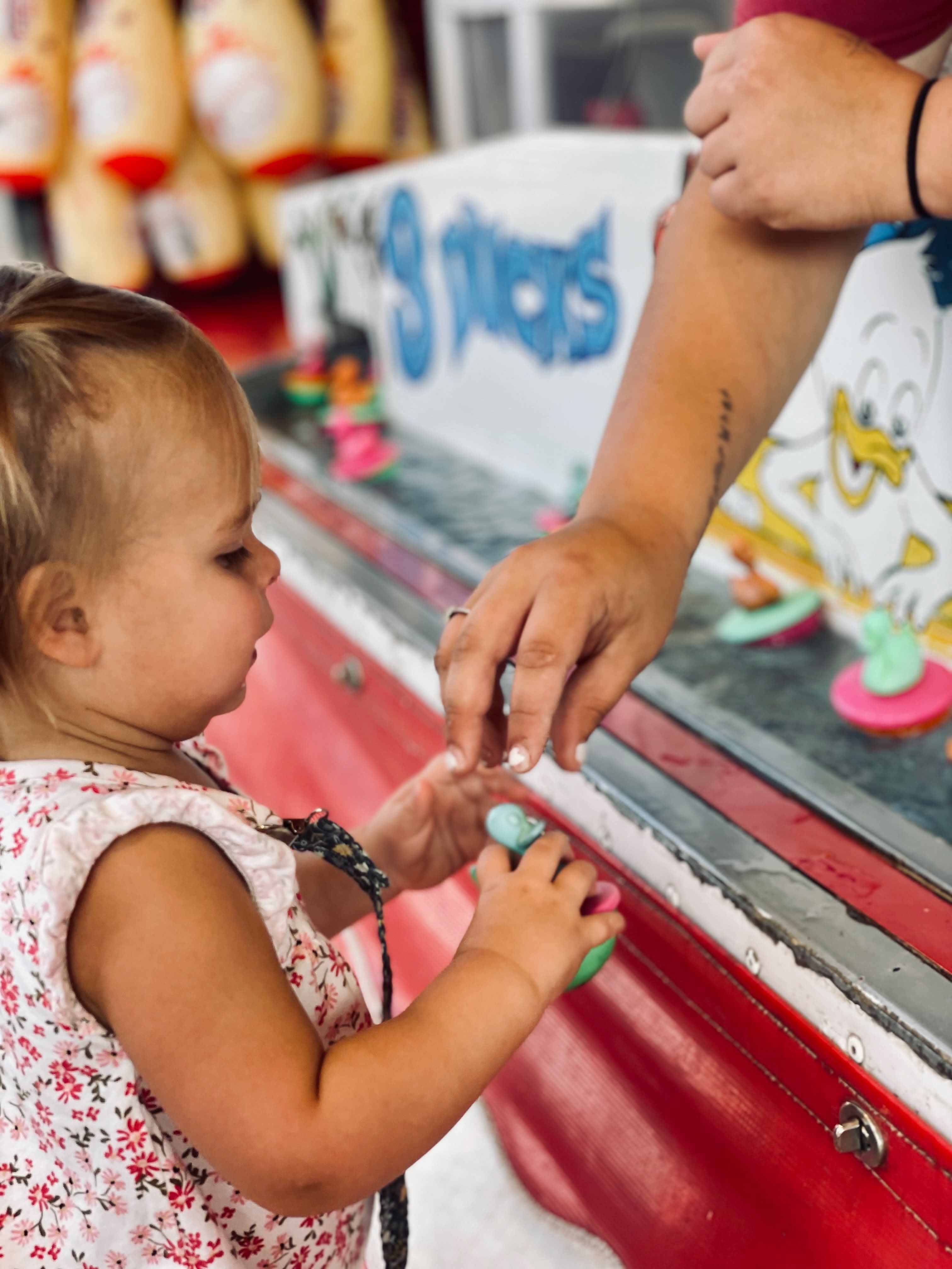 Festival visitors playing the goldfish game on the busy midway