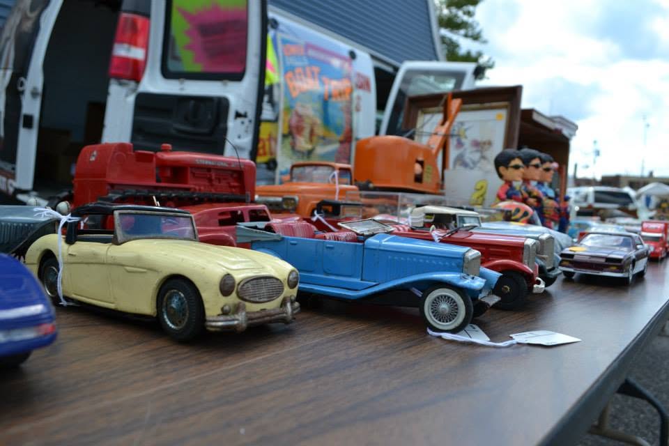 Vintage model cars arranged for sale at a festival vendor table