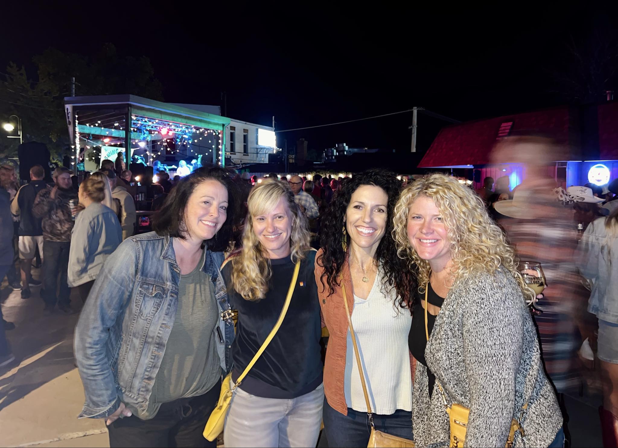 Friends enjoying the outdoor concert crowd after dark