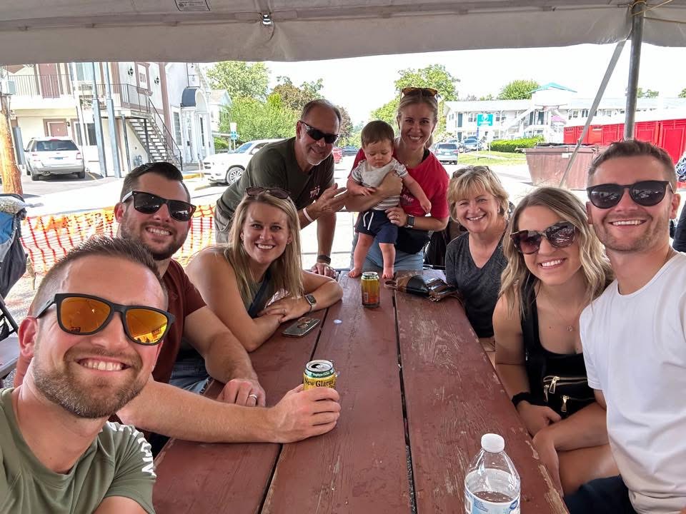 Friends and family gathering around a picnic table during the festival